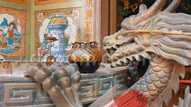 中国风格的原始烛台。 一尊龙铜像和一支燃烧的蜡烛